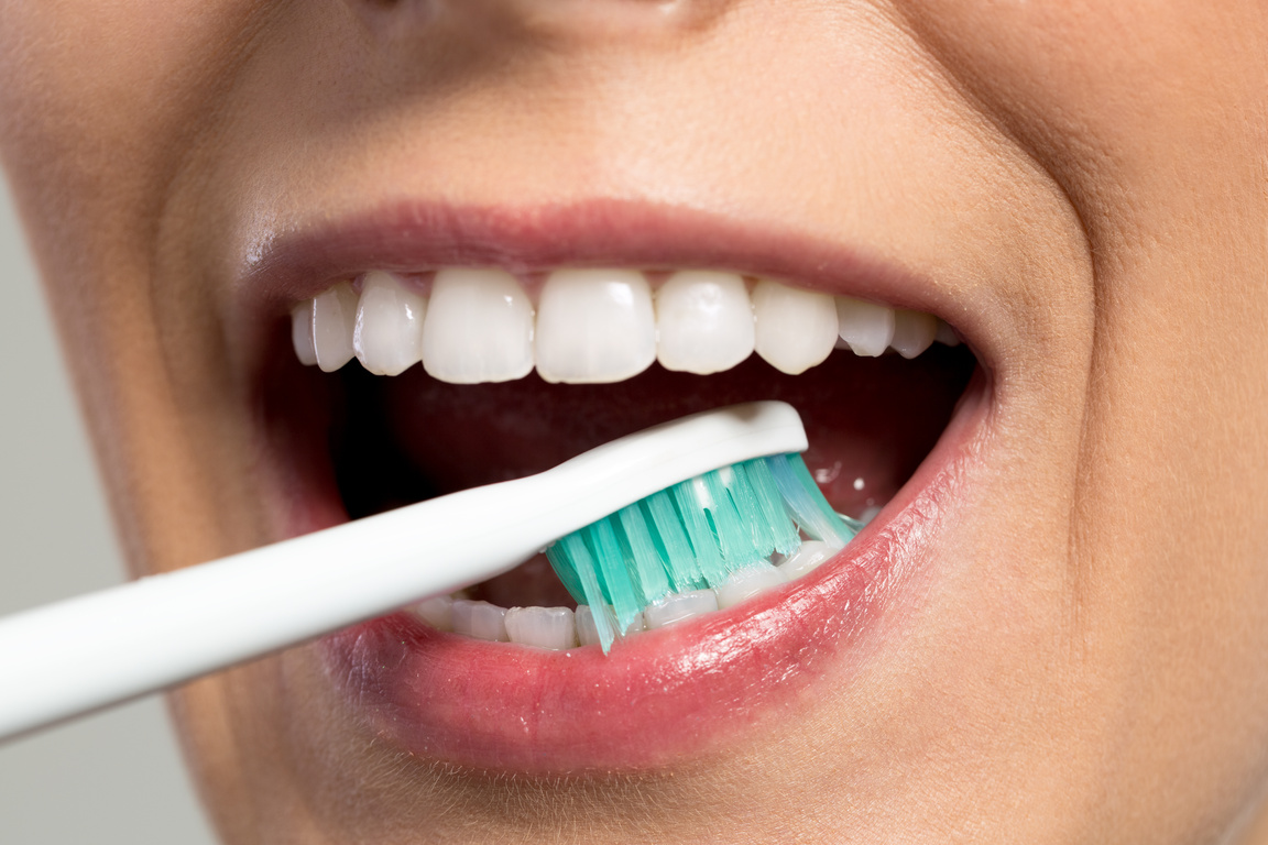 Girl rubbing teeth with toothbrush